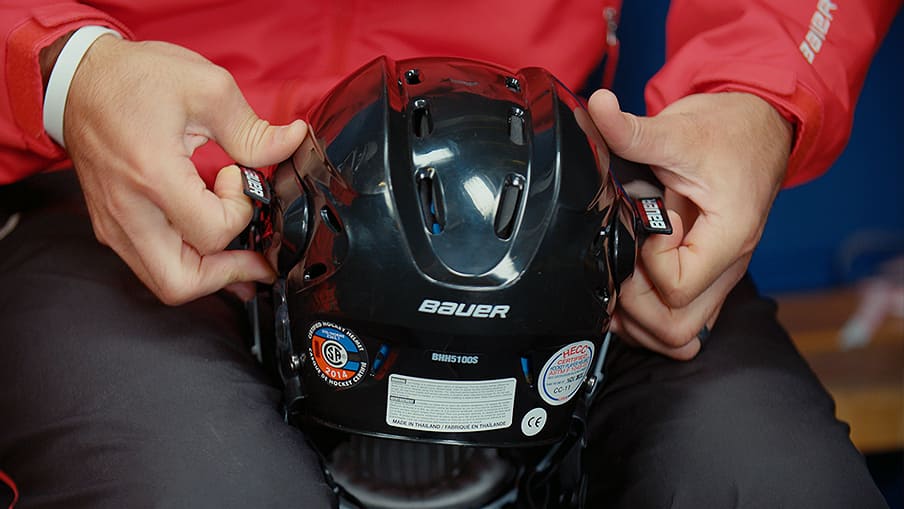 Person adjusting hockey helmet size