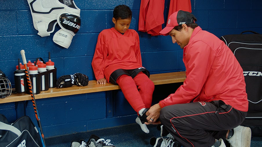 Adult measuring child’s skate size