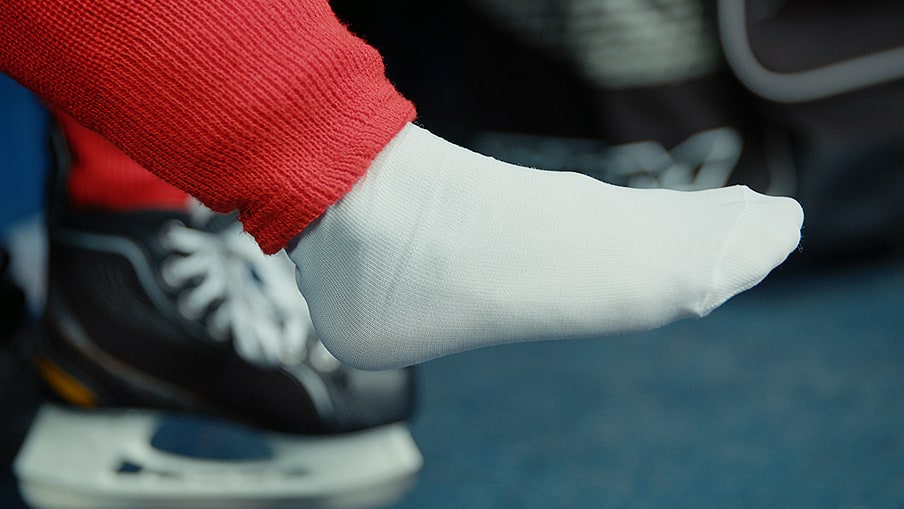 Close up of child’s foot with hockey socks on 