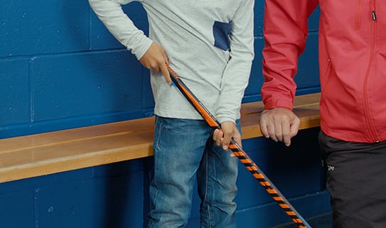 Child holding hockey stick with both hands