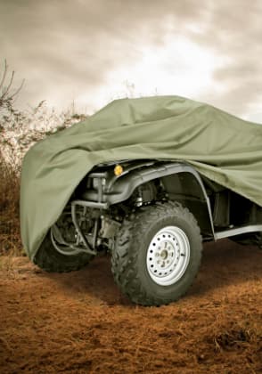 An ATV covered with a weatherproof cover.