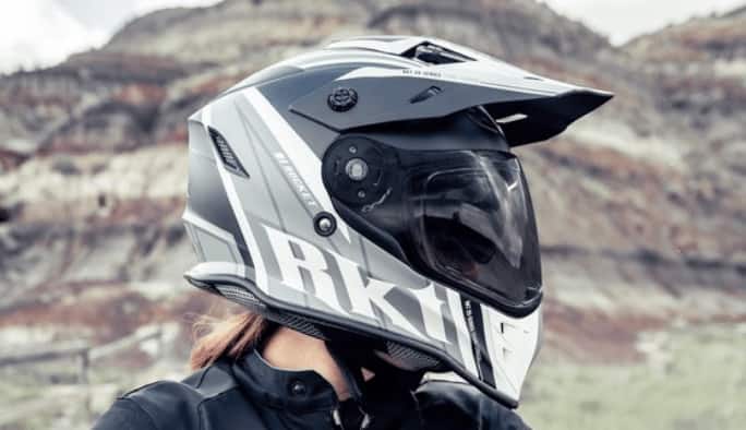 A motorcyclist wearing a grey-and-black motorcycle helmet with a tinted visor.