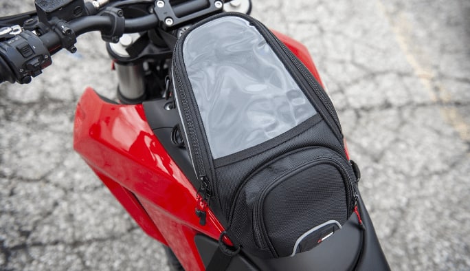 A black Joe Rocket Universal Trans Canada Motorcycle Tank Bag mounted on a red motorcycle.