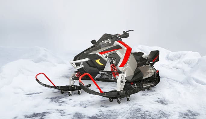 Une motoneige blanche, rouge et noire est placée sur un ensemble de chariots pour motoneige dans un paysage enneigé.