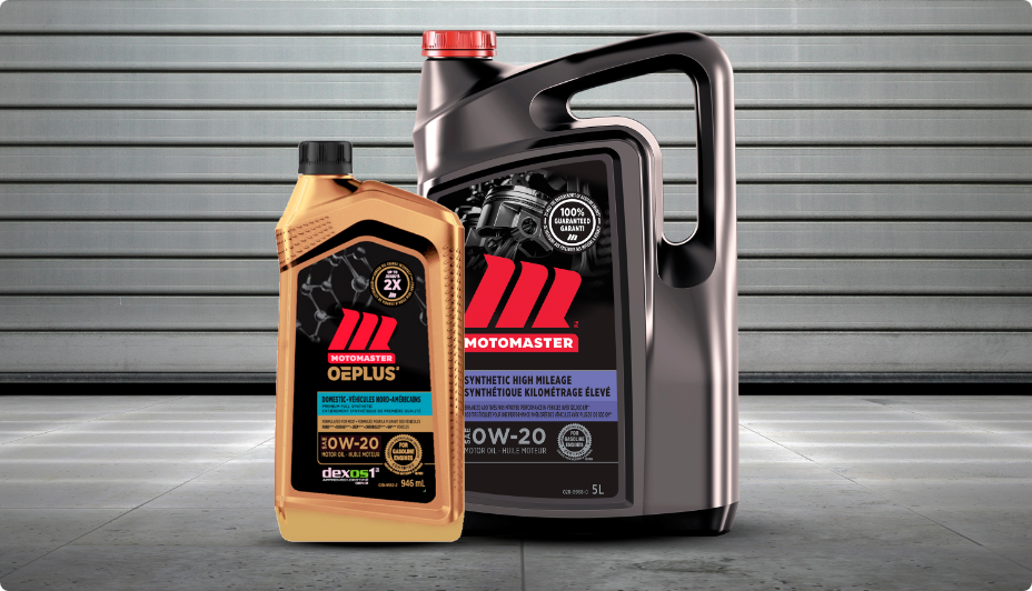 A gold bottle of MotoMaster OEPLUS Import 5W20 Premium Synthetic Oil and a black bottle of MotoMaster 5W20 Synthetic High Mileage Engine Oil stand on the ground in front of a garage door.