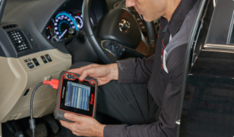 Man holding technological device in car