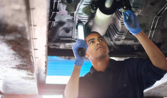 Man inspecting underneath vehicle