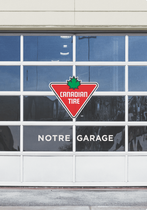 Porte de garage du centre-autos Canadian Tire avec affiche « Notre garage ».