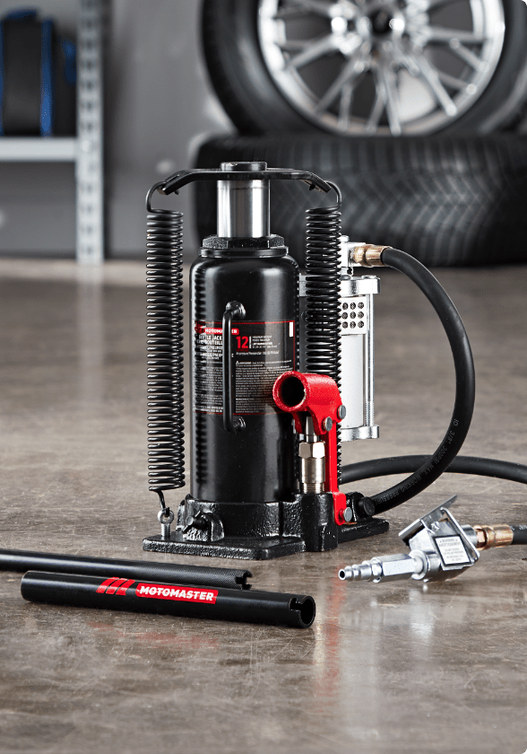 Un cric-bouteille hydraulique MotoMaster muni d'un raccord rapide dans un garage.