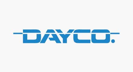 Le logo de Dayco : Le mot-symbole « DAYCO » en bleu comportant une barre blanche traversant le haut des lettres.