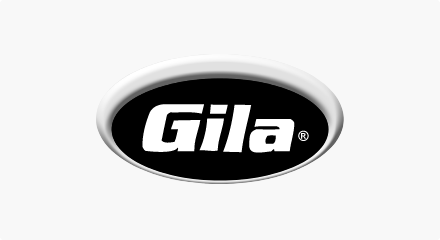 Le logo Gila Window Film : Un mot-symbole « Gila » blanc à l'intérieur d'un ovale noir placé à l'intérieur d'un ovale orange plus grand.