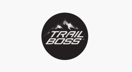 The Trail Boss logo: A drawing of a white mountain above a stacked white “TRAIL BOSS” wordmark, all inside a black circle.