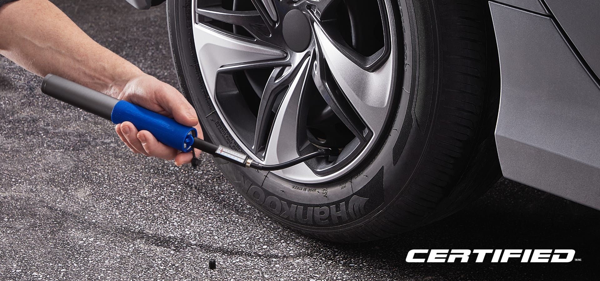 Person using a tool to check tire pressure.