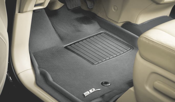 A grey 3D Maxpider floor liner lines the driver’s-side footwell of a car with a beige interior.