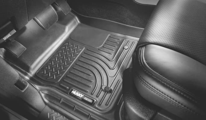 A grey Husky floor liner lines the driver’s-side footwell of a car with a grey interior.