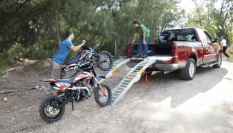 Un père et un fils chargent leurs motocyclettes à l’arrière d’un camion.