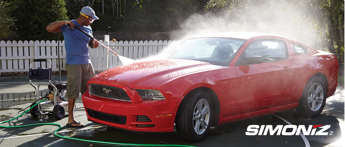 Un homme qui lave une Mustang rouge avec un nettoyeur haute pression 