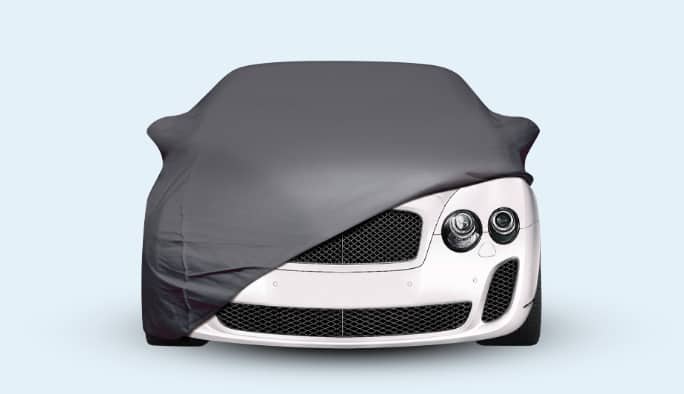 A gray car cover partially covering a car.