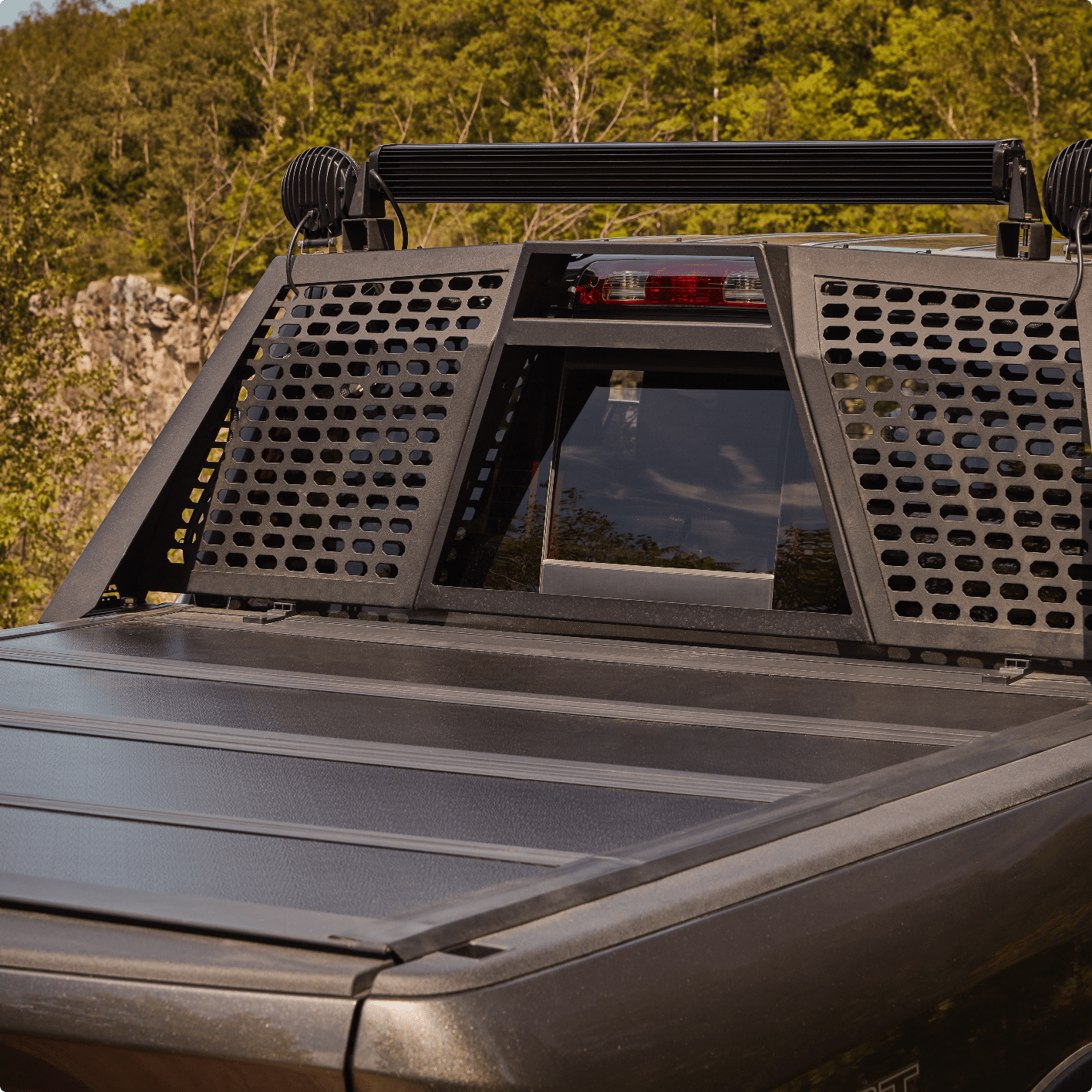 Black truck with folding tonneau cover and mounted black steel cargo rack.