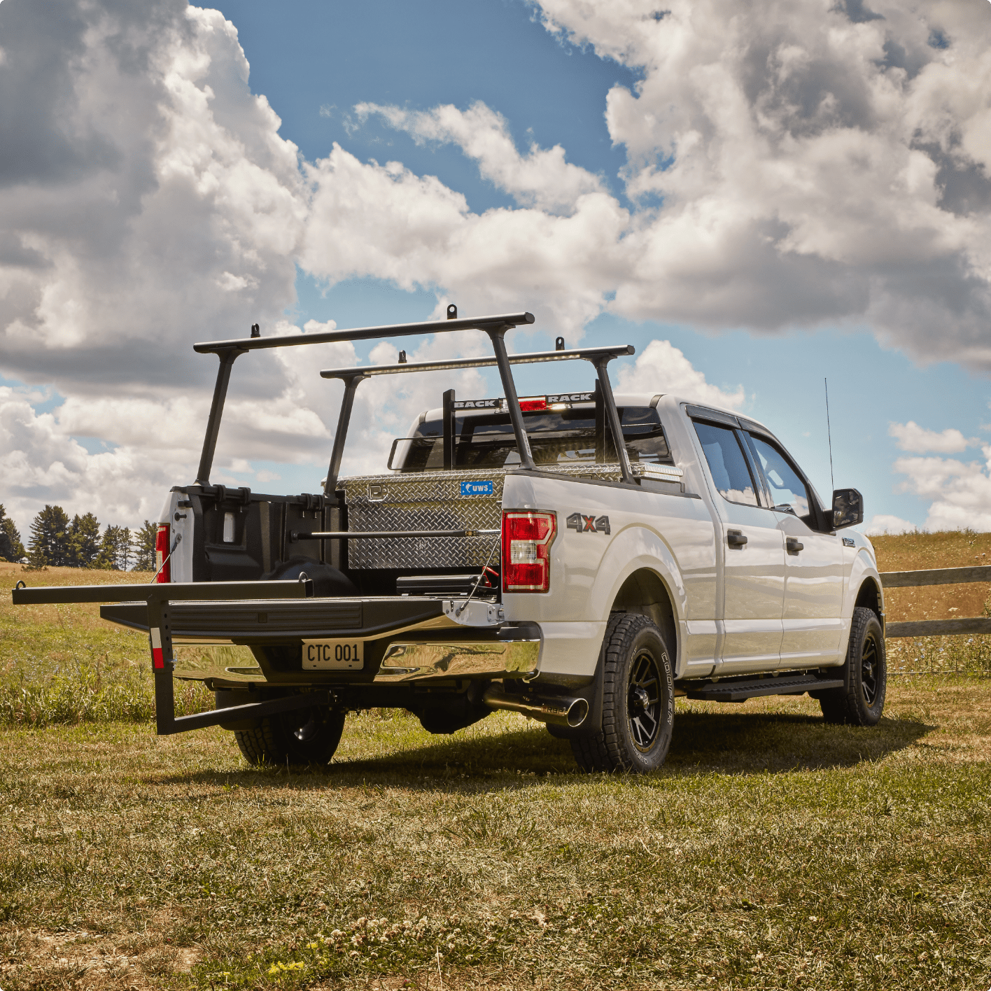 White truck in a field with a mounted black steel headache rack.
