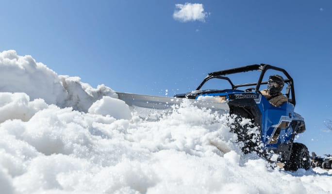 A person plowing snow with his UTV.