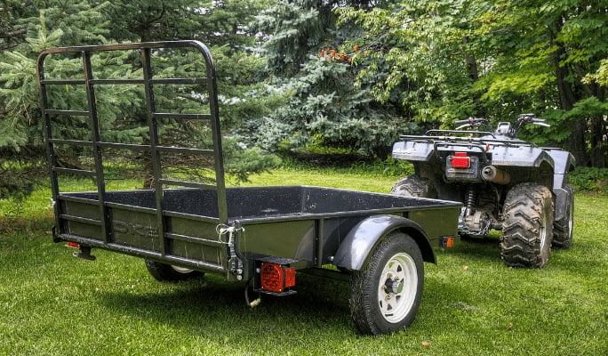 A trailer in a lush green patch. 
