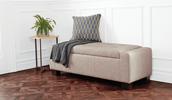 Une table d'appoint CANVAS Hexagon et un pouf de rangement CANVAS Louisa dans une chambre. 