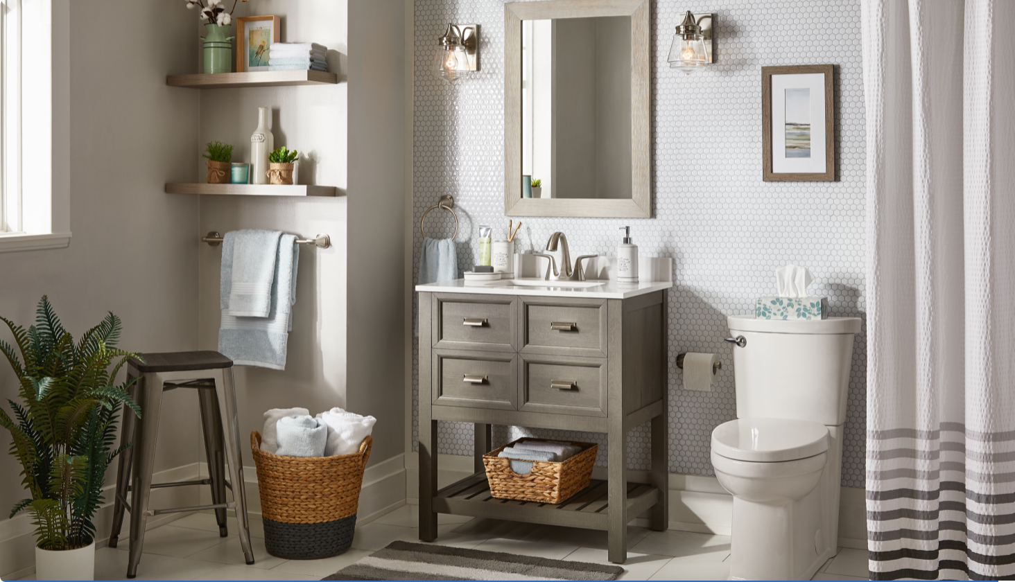 Grey and white bathroom with towel baskets, shower curtains, floor plant and decor