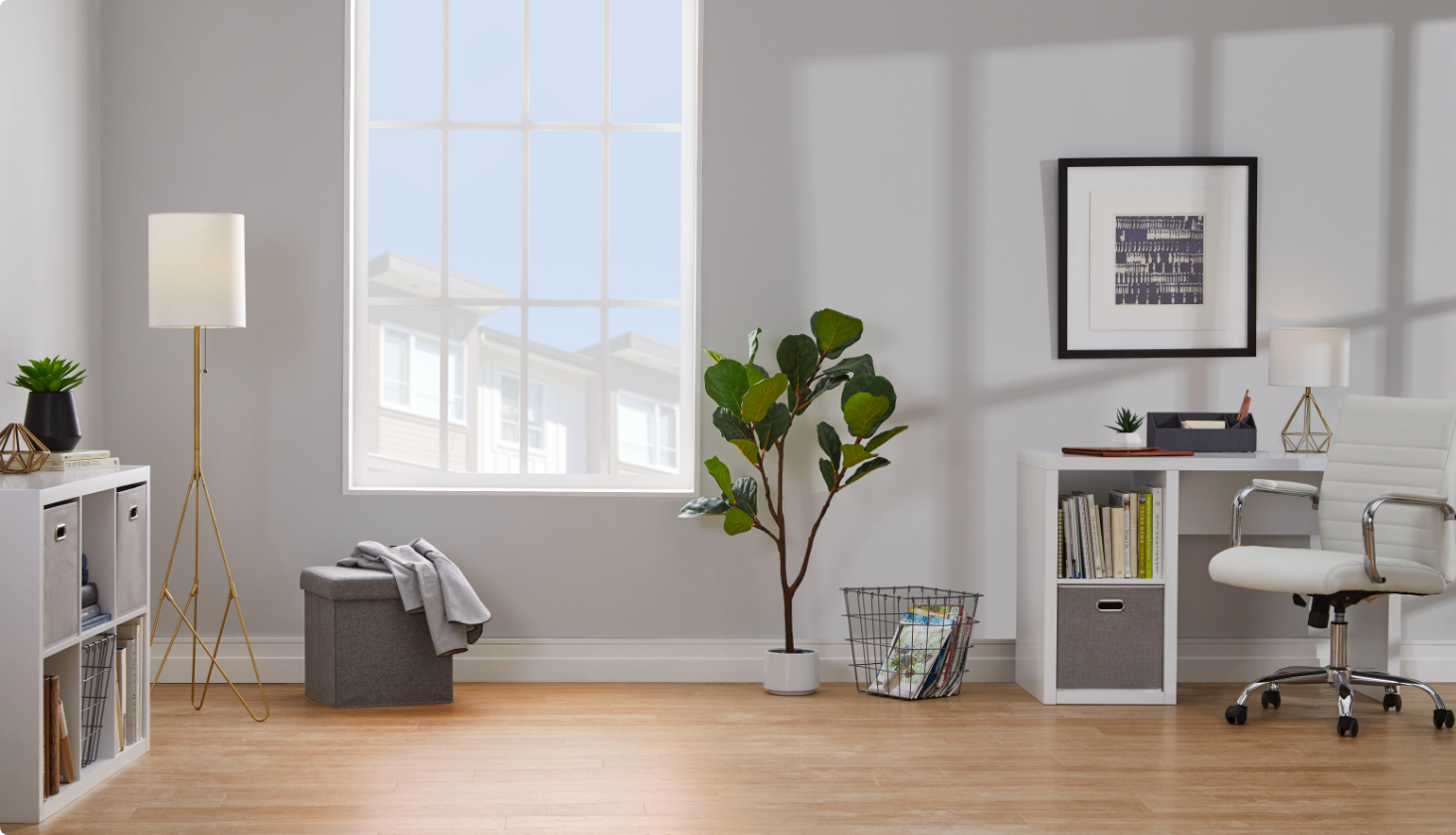 Bureau à domicile avec chaise blanche, bureau, plante verte au sol, lampadaire et articles décoratifs.