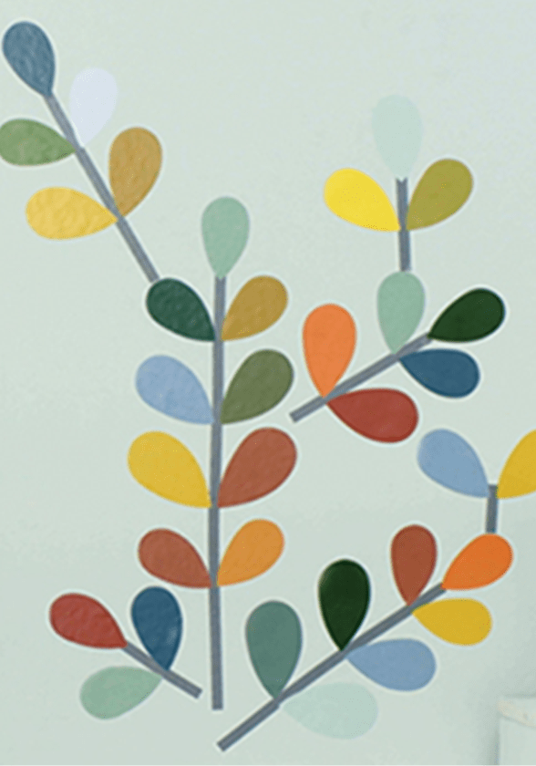 Décalcomanie multicolore à motif de feuilles sur un mur vert.