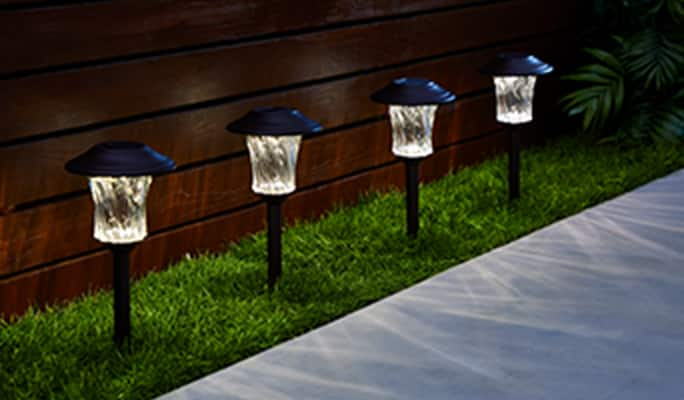 Black NOMA Lake Effect glass path lights lining a walkway.