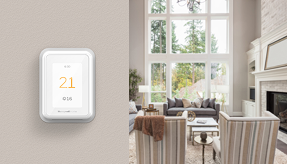 Un thermostat intelligent sur un mur affichant la température de 21 °C à l'intérieur et de 16 °C à l'extérieur.