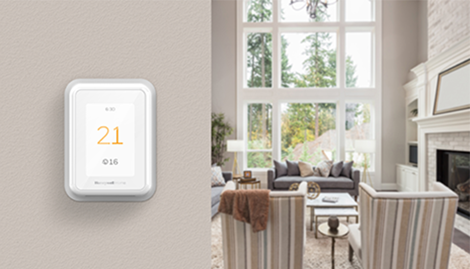 Smart thermostat on a wall displaying the temperature as 21 degrees Celsius indoors and 16 degrees outdoors.