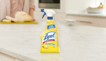 Un flacon pulvérisateur de nettoyant tout usage Lysol sur un comptoir de cuisine blanc.