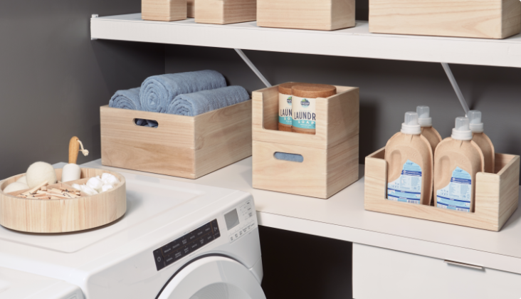 Wood storage bins and crates on a counter and washing machine.