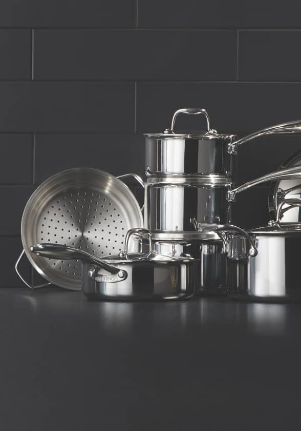 : Stacked stainless steel pots and pans.