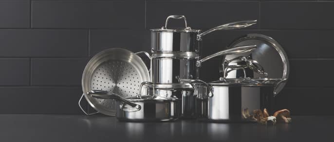 : Stacked stainless steel pots and pans.