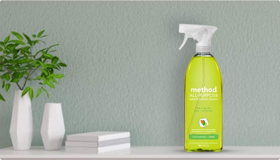 Method all purpose cleaner on a shelf with 3 books and a plant.