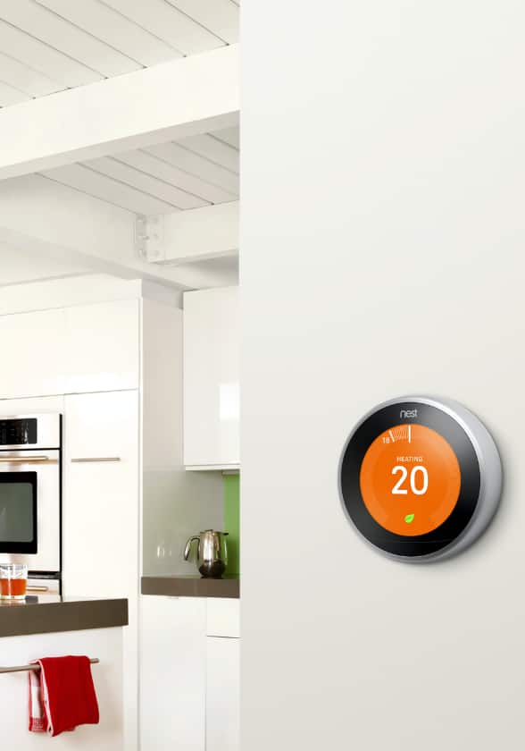 A modern kitchen with a smart thermostat on the wall.