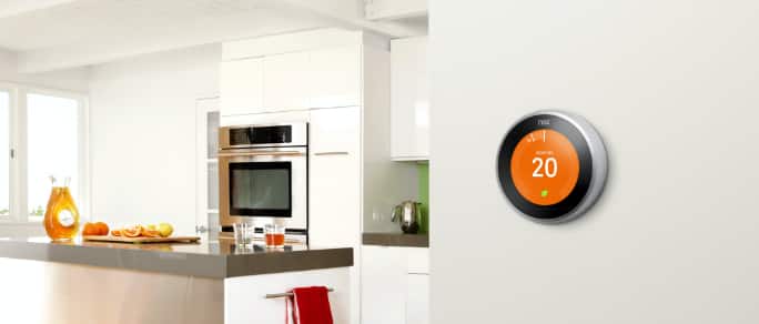 A modern kitchen with a smart thermostat on the wall.