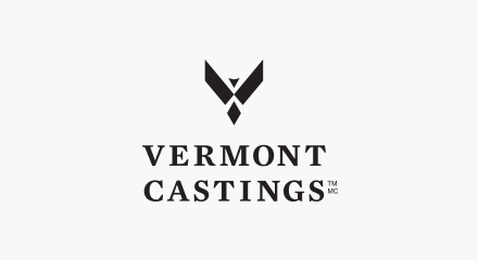 Le logo de Vermont Castings : Un mot-symbole superposé « VERMONT CASTINGS » en noir avec un oiseau noir stylisé aux ailes déployées placé au-dessus des deux mots.