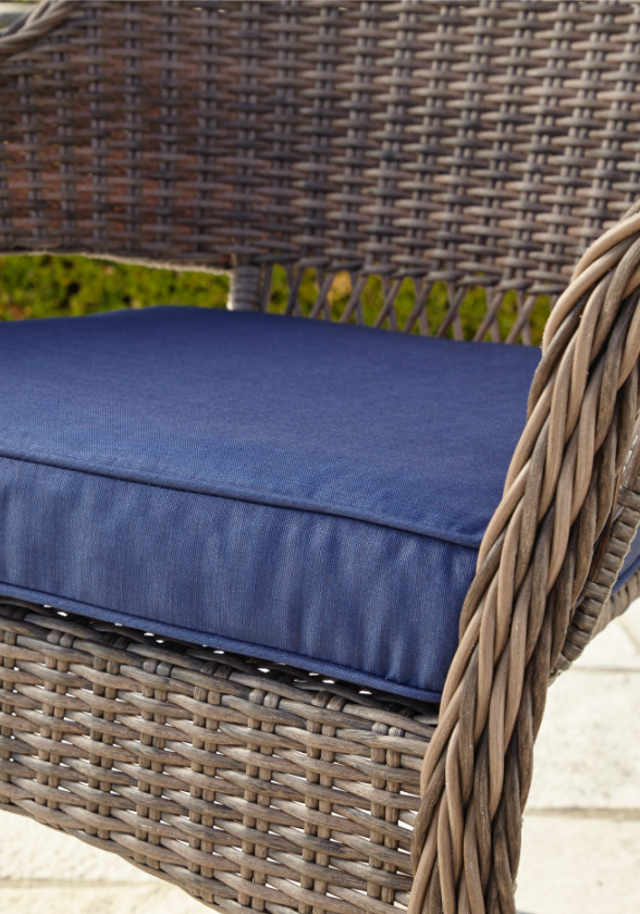 Gros plan d’un coussin bleu conçu pour un fauteuil de jardin