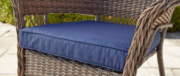 Gros plan d’un coussin bleu conçu pour un fauteuil de jardin
