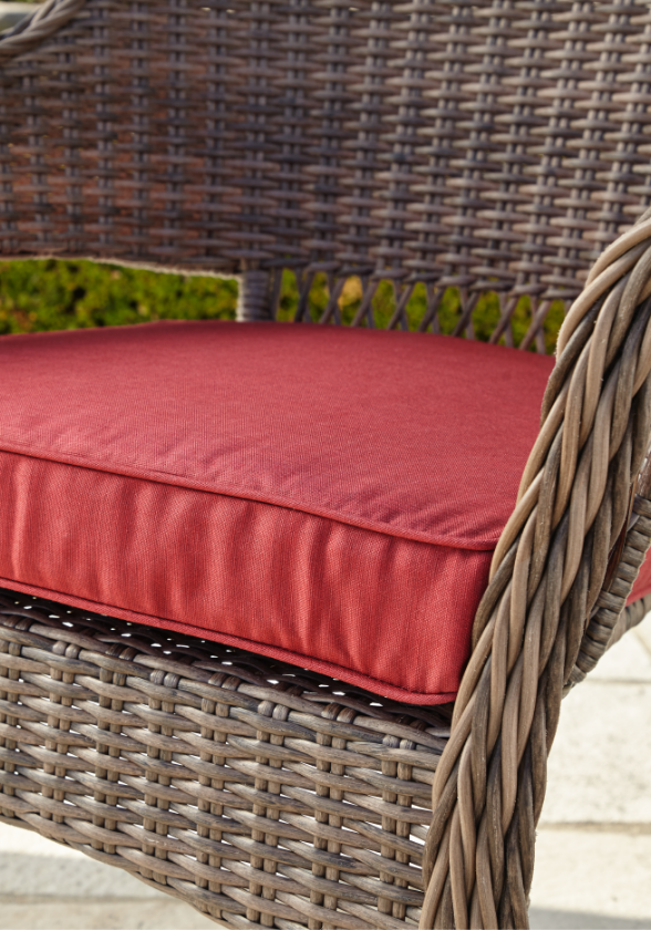 Gros plan d’un coussin rouge conçu pour un fauteuil de jardin 
