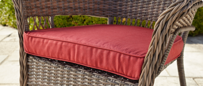 Gros plan d’un coussin rouge conçu pour un fauteuil de jardin 