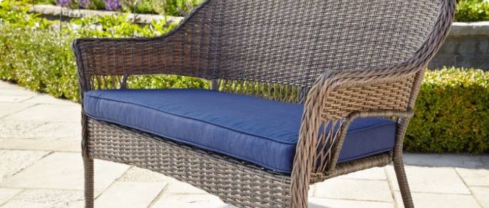 Close-up image of a wide, blue cushion designed for a patio loveseat.