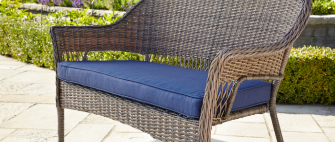 Gros plan d’un large coussin bleu conçu pour une causeuse de jardin