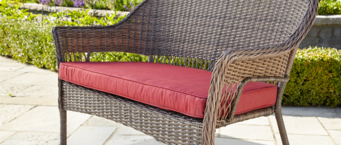 Gros plan d’un large coussin rouge conçu pour une causeuse de jardin 