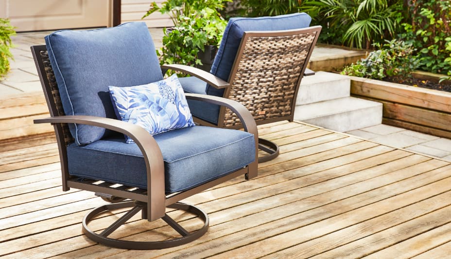 2 Swivel/Rocker patio chairs with cushions. One is facing forward on an angle & one is backwards at an angle