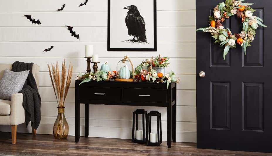 Bat decals, fall gourds and a harvest wreath decor the inside an entryway